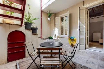a dining room with a table and chairs and a red door at Filopapou Pearl on Acropolis Hill in Athens