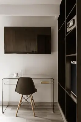 a glass desk with a black chair in a room at Alassia Hotel in Athens