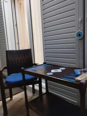 a table and a chair sitting next to a table and a window at Renovated Basement Duplex with Patio and Folk Decor in the Heart of Athens in Athens