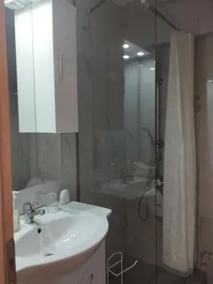 a bathroom with a white sink and a shower at Renovated Basement Duplex with Patio and Folk Decor in the Heart of Athens in Athens