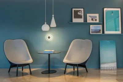 two chairs and a table in front of a blue wall at Amarilia Hotel in Athens