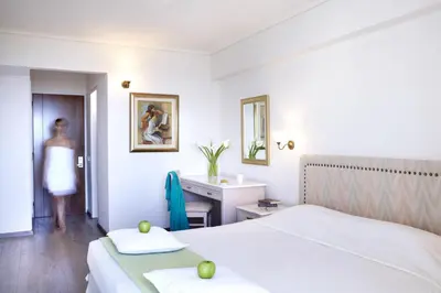 a hotel room with two beds and a sink at Amarilia Hotel in Athens