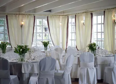 a dining room with white tables and chairs and windows at Amarilia Hotel in Athens