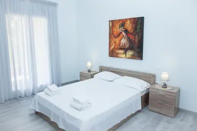 a bedroom with two beds and a painting on the wall at Sunny and minimal apt in Glyfada with 3 bdrm in Athens