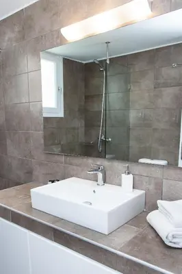 a bathroom with a white sink and a mirror at Sunny and minimal apt in Glyfada with 3 bdrm in Athens