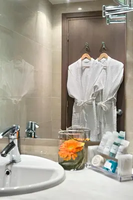 a bathroom counter with a sink and a mirror at Amalia Hotel Athens in Athens