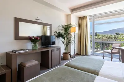 a hotel room with a bed and a television and a balcony at Amalia Hotel Athens in Athens