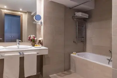 a bathroom with a tub and a sink at Amalia Hotel Athens in Athens