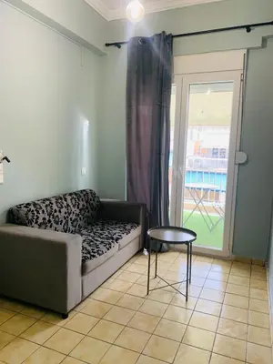 a living room with a couch and a table and a window at Athens City Themis 9 in Athens