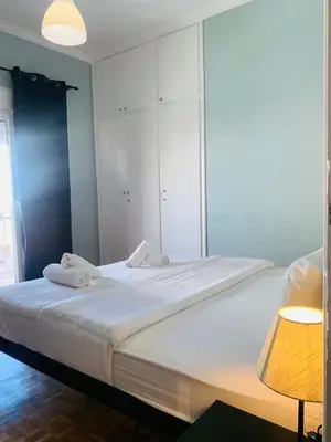 a bedroom with a large white bed with a lamp at Athens City Themis 9 in Athens