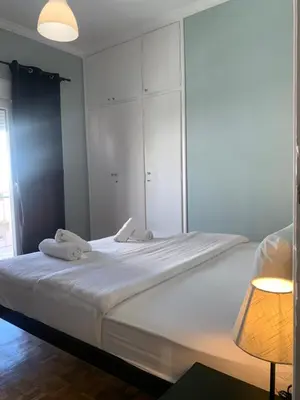 a bedroom with a large bed with white cabinets and a lamp at Athens City Themis 9 in Athens