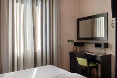 a hotel room with a desk and a mirror at Delphi Art Hotel by Prima Hotels in Athens
