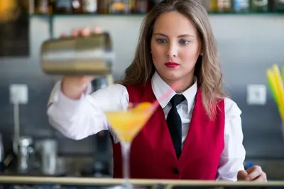 a woman bartender making a cocktail in a bar at Delphi Art Hotel by Prima Hotels in Athens