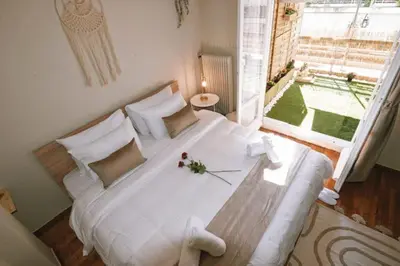 a large white bed in a room with a large window at Cozy Apartment in the heart of Athens! in Athens