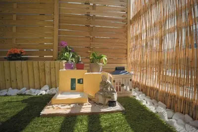 a miniature garden with a house in the grass at Cozy Apartment in the heart of Athens! in Athens