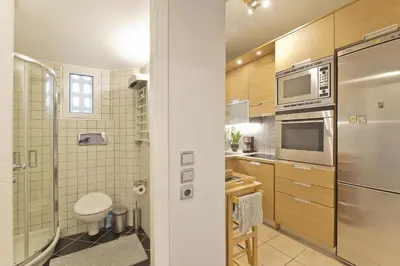a kitchen with a refrigerator and a sink at Seascape Modern Vouliagmeni Apt near Beaches in Athens