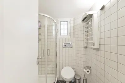 a bathroom with a toilet and a glass shower at Seascape Modern Vouliagmeni Apt near Beaches in Athens