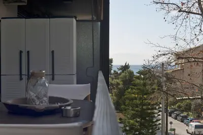 a vase on a table on a balcony with a view at Seascape Modern Vouliagmeni Apt near Beaches in Athens