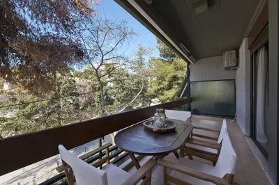 a table and chairs on the balcony of a house at Seascape Modern Vouliagmeni Apt near Beaches in Athens