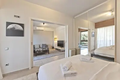 a bedroom with a bed and a large mirror at Seascape Modern Vouliagmeni Apt near Beaches in Athens