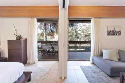 a bedroom with a bed and a sliding glass door at Seascape Modern Vouliagmeni Apt near Beaches in Athens