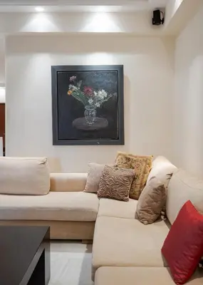 a living room with a couch and a vase of flowers at Voula Riviera Apartment in Athens