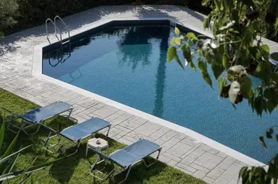 a swimming pool with two chairs and a pair at Voula Riviera Apartment in Athens