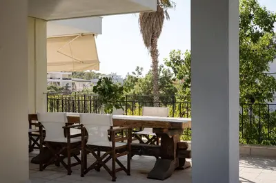 a table and chairs with an umbrella on a patio at Voula Riviera Apartment in Athens