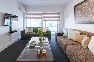 a living room with a couch and a table at Sun & Sea Suite, Kavouri in Athens