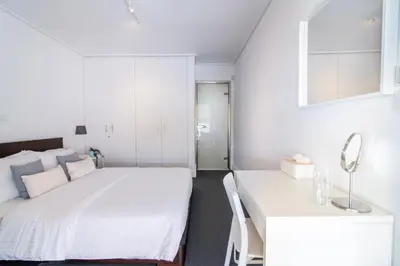 a bedroom with a white bed and a white table at Sun & Sea Suite, Kavouri in Athens