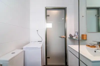 a white bathroom with a shower and a sink at Sun & Sea Suite, Kavouri in Athens