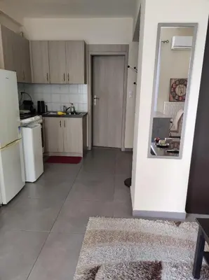 an empty kitchen with a white refrigerator and a table at Pegasus cosy house in Athens