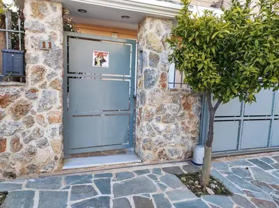 a blue garage door with a tree in front of a building at Pegasus cosy house in Athens