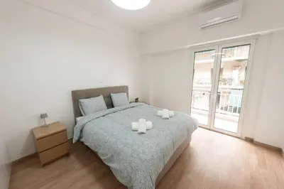 a bedroom with a bed with two candles on it at Spacious flat 10min from subway stations (BODA_B3) in Athens