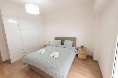 a bedroom with a bed with two white towels on it at Spacious flat 10min from subway stations (BODA_B3) in Athens