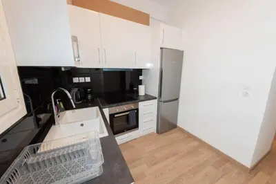a kitchen with white cabinets and a stainless steel refrigerator at Spacious flat 10min from subway stations (BODA_B3) in Athens