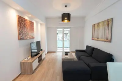 a living room with a couch and a tv at Spacious flat 10min from subway stations (BODA_B3) in Athens