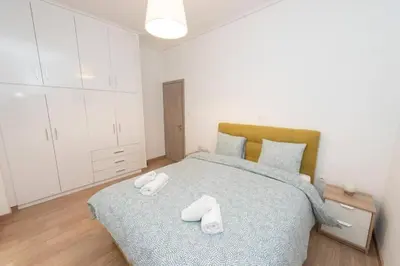 a bedroom with a bed with two white towels on it at Spacious flat 10min from subway stations (BODA_B3) in Athens
