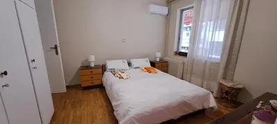 a bedroom with a bed with two pillows and a window at Sq Varnava apartment Athens in Athens