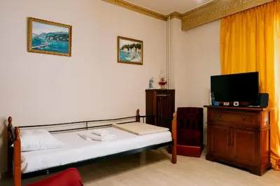 a bedroom with a bed and a tv and a chair at Sq Varnava apartment Athens in Athens