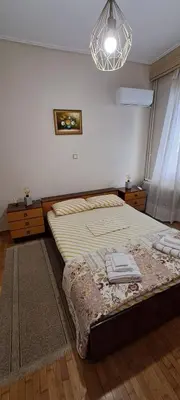 a bedroom with a bed and a chandelier at Sq Varnava apartment Athens in Athens