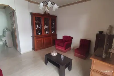 a living room with two red chairs and a table at Sq Varnava apartment Athens in Athens