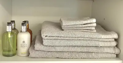 a stack of towels next to a bottle of soap and a stack of towelsktop at Filothei Luxury Apartment 110m2 in Athens