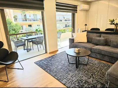 a living room with a couch and a table at Filothei Luxury Apartment 110m2 in Athens