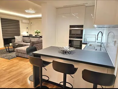 a kitchen and living room with a counter and chairs at Filothei Luxury Apartment 110m2 in Athens