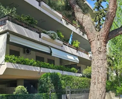 a building with plants on the balconies and a tree at Filothei Luxury Apartment 110m2 in Athens