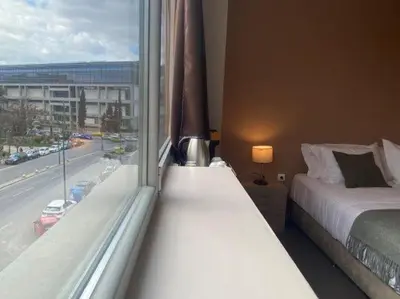 a bedroom with a bed and a large window at Athens Gem in Athens