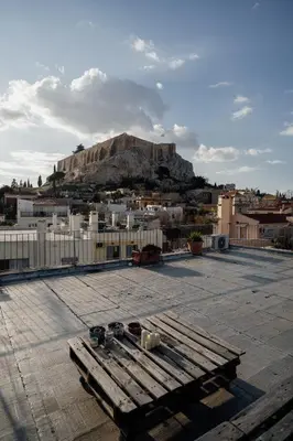 a bench sitting on top of a roof with a mountain at Plaka With Acropolis Rooftop View Access in Athens