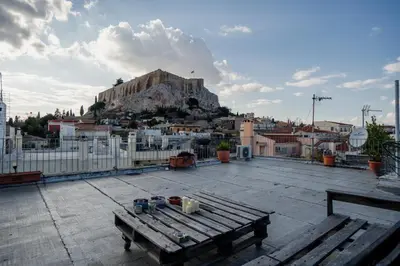 a view of a city with a bench and a mountain at Plaka With Acropolis Rooftop View Access in Athens