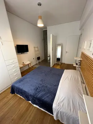 a bedroom with a large bed and a tv at Harmony Luxury Grand Suite in Athens